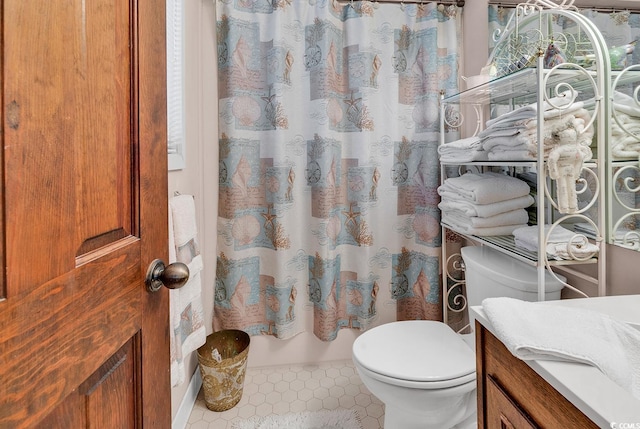 bathroom with walk in shower, tile patterned flooring, vanity, and toilet