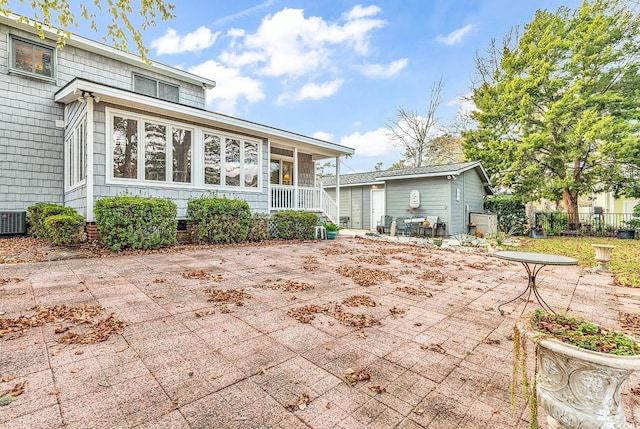 rear view of house with central AC and a patio