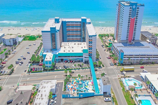 birds eye view of property with a water view and a beach view