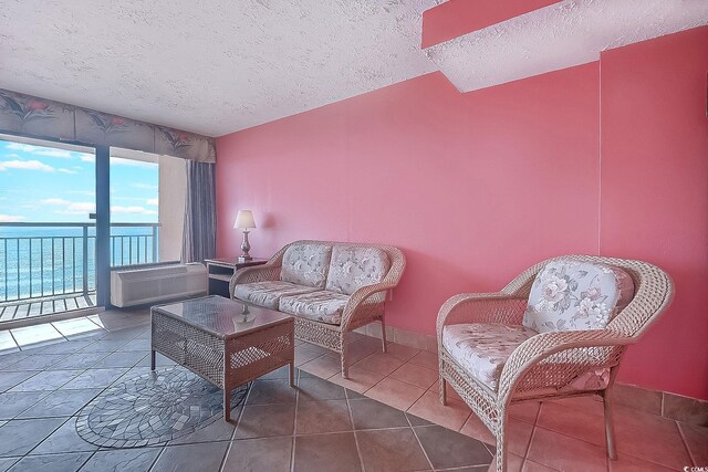 tiled living room with a textured ceiling and a water view