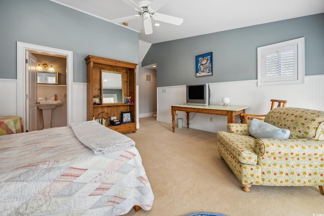 bedroom with light colored carpet, lofted ceiling, ceiling fan, and connected bathroom