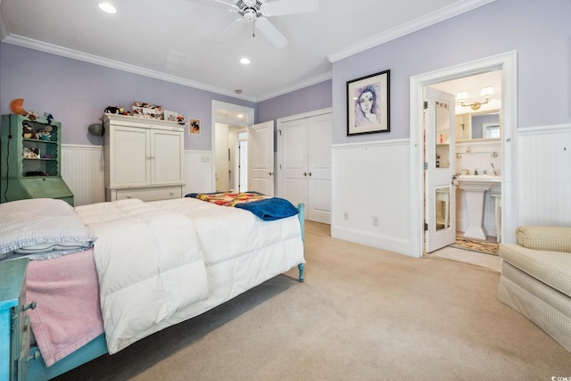 carpeted bedroom with ensuite bathroom, ceiling fan, a closet, and crown molding