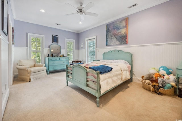 carpeted bedroom with ceiling fan and ornamental molding