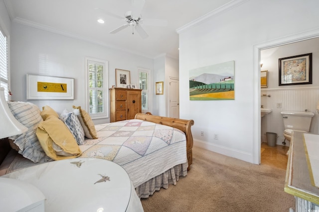 bedroom featuring connected bathroom, light colored carpet, ceiling fan, and crown molding