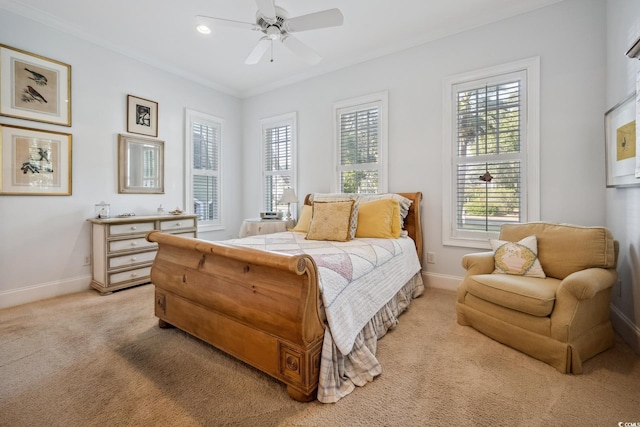 carpeted bedroom with ornamental molding and ceiling fan