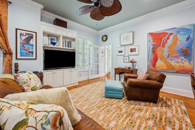 living room featuring ornamental molding, light wood-type flooring, and ceiling fan