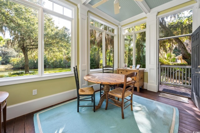 sunroom / solarium featuring ceiling fan, a healthy amount of sunlight, and beam ceiling