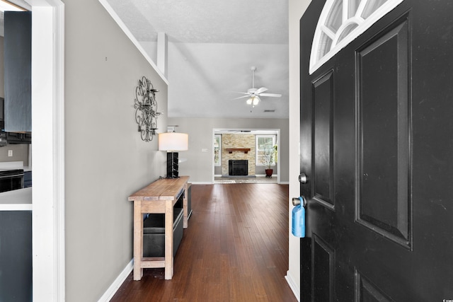 entrance foyer featuring a fireplace, lofted ceiling, ceiling fan, baseboards, and hardwood / wood-style flooring