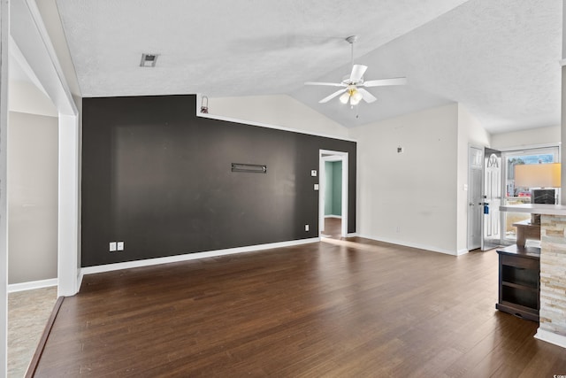 unfurnished living room with baseboards, lofted ceiling, ceiling fan, wood finished floors, and a textured ceiling