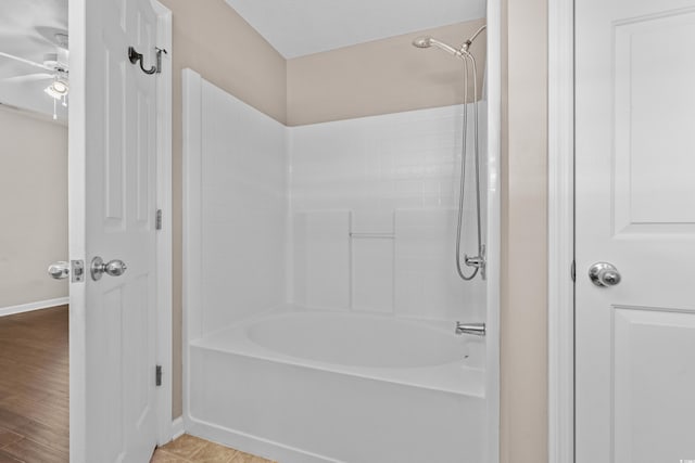 bathroom featuring  shower combination, ceiling fan, and baseboards