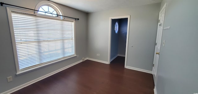 unfurnished room featuring baseboards and wood finished floors