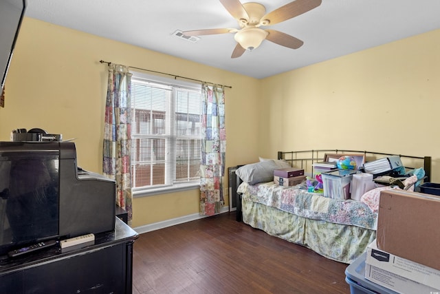 bedroom with a ceiling fan, baseboards, visible vents, and wood finished floors