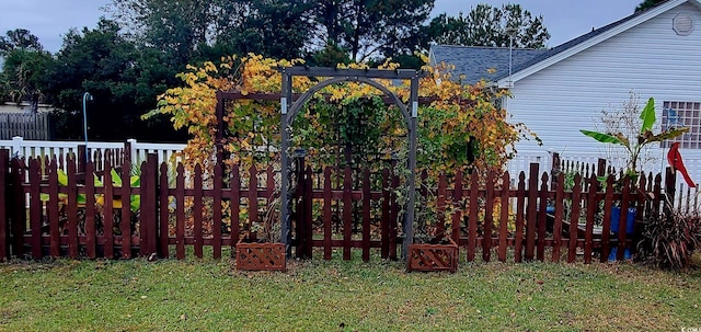 view of gate featuring fence and a lawn