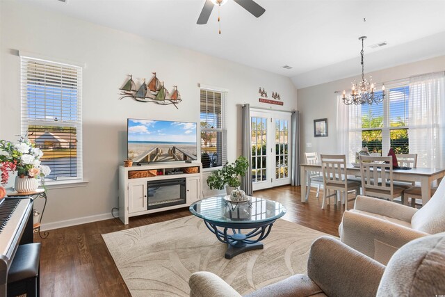 living room featuring dark wood-type flooring, vaulted ceiling, and ceiling fan with notable chandelier