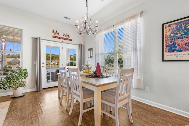 dining space with hardwood / wood-style floors and a chandelier