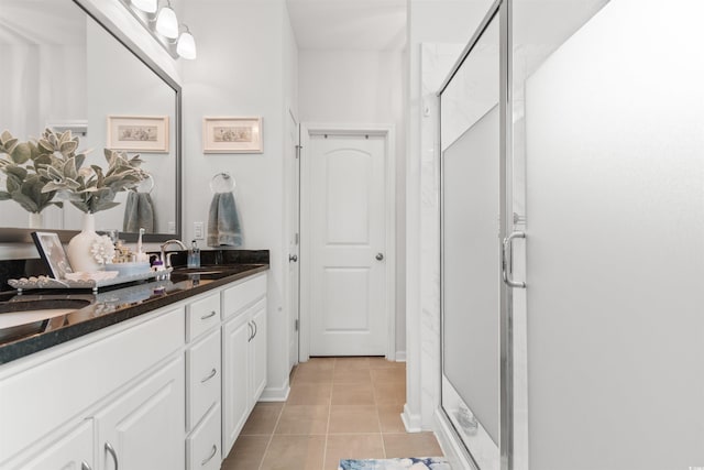 bathroom with vanity, a shower with shower door, and tile patterned floors