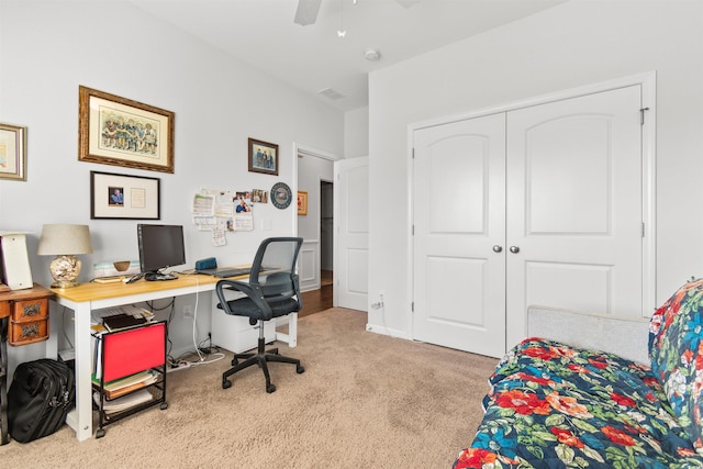 carpeted office space featuring ceiling fan