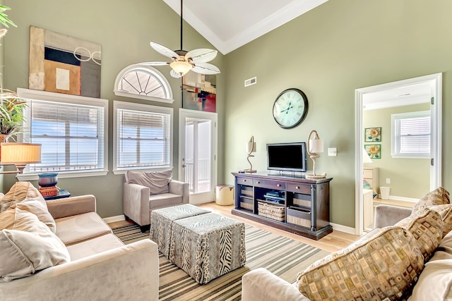 living room with crown molding, high vaulted ceiling, ceiling fan, and light wood-type flooring