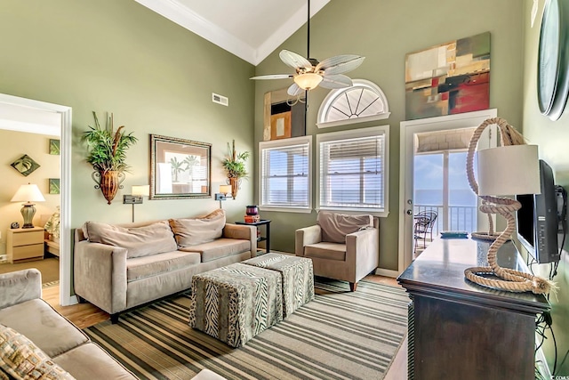 living room featuring high vaulted ceiling, crown molding, ceiling fan, and light hardwood / wood-style flooring