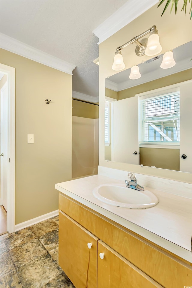 bathroom featuring vanity, a textured ceiling, and ornamental molding