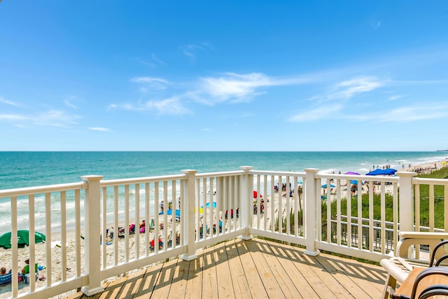 wooden deck with a beach view and a water view