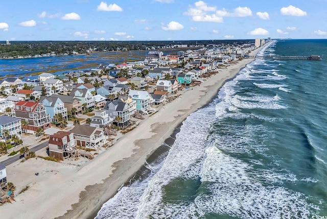 drone / aerial view featuring a beach view and a water view