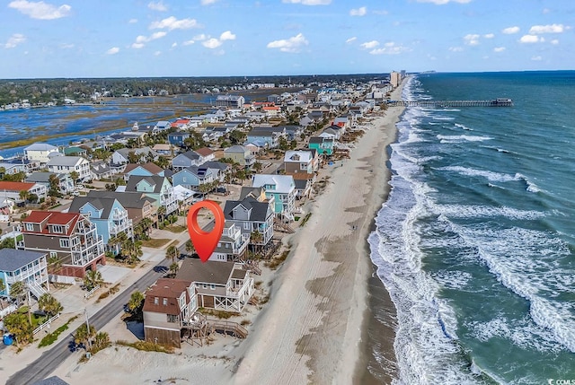 birds eye view of property with a water view and a beach view