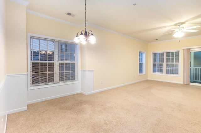 carpeted spare room featuring ornamental molding and ceiling fan with notable chandelier