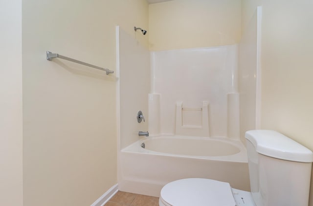 bathroom featuring tile patterned floors, toilet, and shower / washtub combination