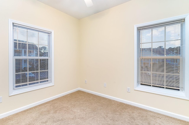 carpeted spare room with ceiling fan