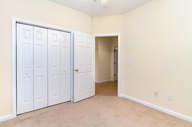 unfurnished bedroom featuring a closet and light carpet