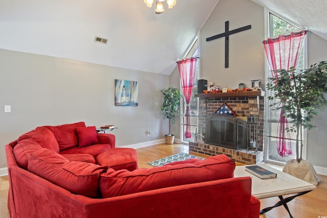 living room with a fireplace, hardwood / wood-style flooring, and vaulted ceiling