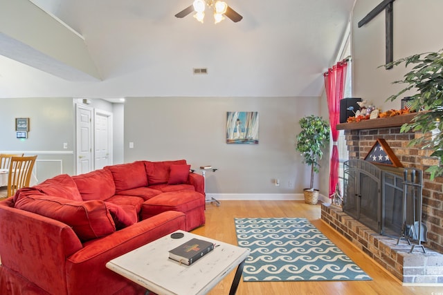 living room with a fireplace, vaulted ceiling, light hardwood / wood-style floors, and ceiling fan