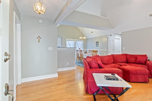 living room featuring an inviting chandelier, vaulted ceiling, and wood-type flooring