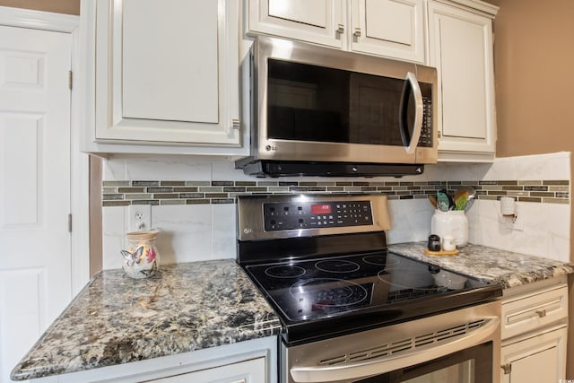 kitchen with cream cabinets, decorative backsplash, stainless steel appliances, and dark stone counters