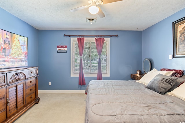 carpeted bedroom featuring ceiling fan and a textured ceiling