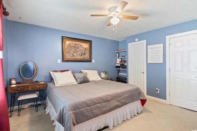 carpeted bedroom with a textured ceiling and ceiling fan