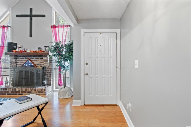 entryway with a fireplace and light hardwood / wood-style floors