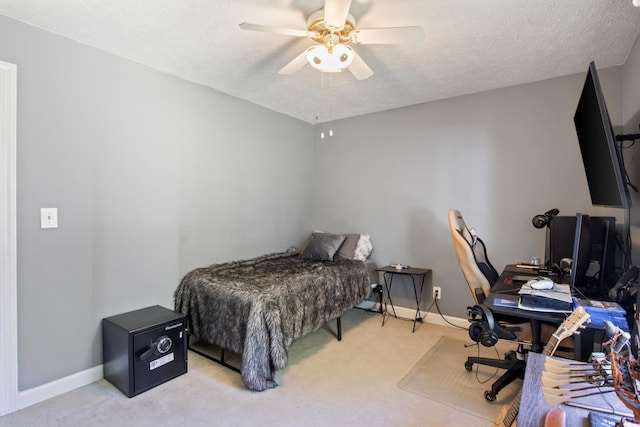 bedroom featuring ceiling fan, light carpet, and a textured ceiling