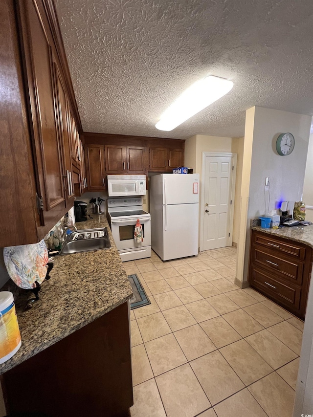 2805 N Ocean Blvd Unit 107, Myrtle Beach, SC 29577 - kitchen featuring white appliances, a sink, light tile patterned floors, dark brown cabinets, and a textured ceiling