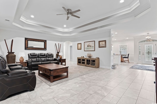 living room with visible vents, a tray ceiling, recessed lighting, arched walkways, and crown molding