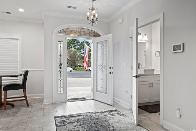 entrance foyer featuring a chandelier, visible vents, baseboards, and ornamental molding