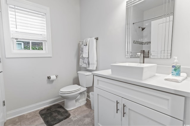 full bathroom featuring vanity, toilet, baseboards, and walk in shower