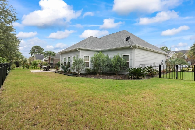 view of home's exterior featuring a patio area, a lawn, a fenced backyard, and a shingled roof