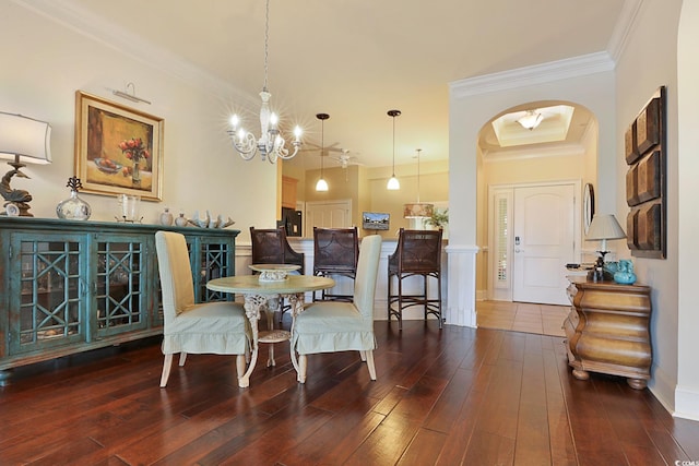 dining area featuring wood-type flooring, crown molding, and an inviting chandelier