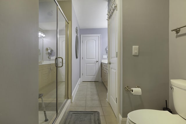 bathroom with tile patterned floors, a shower with door, vanity, and toilet