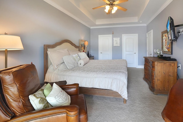 bedroom with dark colored carpet, a tray ceiling, ceiling fan, and ornamental molding