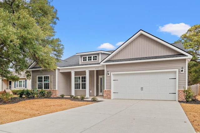 craftsman-style home featuring an attached garage, brick siding, driveway, and roof with shingles