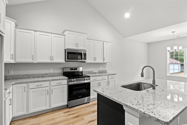608 Britt St, Georgetown, SC 29440 - kitchen featuring appliances with stainless steel finishes, a sink, high vaulted ceiling, white cabinetry, and light wood finished floors