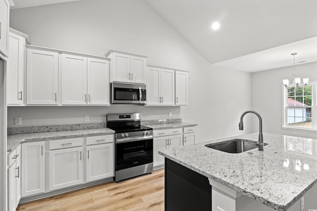 kitchen featuring a sink, stainless steel appliances, white cabinets, light wood-type flooring, and a chandelier